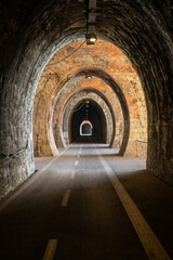 Fototapeta na wymiar Cycle path in Liguria built on the old train route. Tunnel made from red bricks
