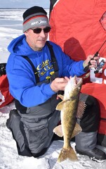 An ice angler with a walleye 
