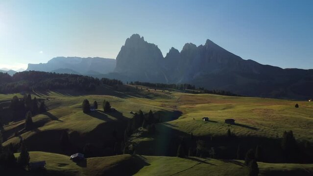 Seiser Alm Alpe di Siusi at Summer in Italian Dolomites, South Tyrol Trentino Alto Adige, Italy. Alpine green meadow, wooden cabin hut. Sassolungo and Sassopiatto mountains.