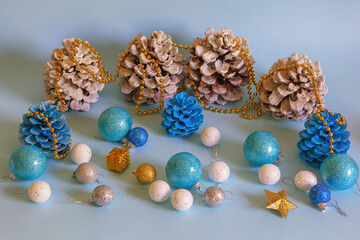 Christmas decorations. White and blue pine cones and Christmas balls on blue background . Copy space