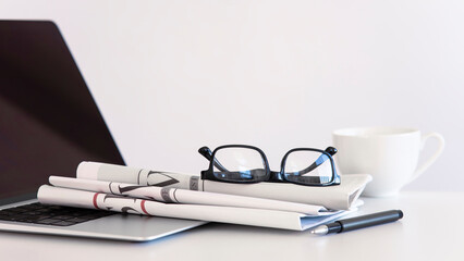 Newspaper with computer on table