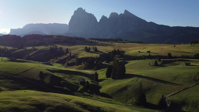 Seiser Alm Alpe di Siusi at Summer in Italian Dolomites, South Tyrol Trentino Alto Adige, Italy. Alpine green meadow, wooden cabin hut. Sassolungo and Sassopiatto mountains.