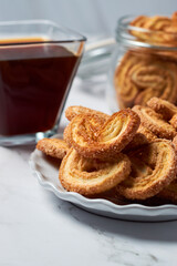 Puff pastry cookies palmier or elephant ears, caramelized and crunchy pastry with coffee. Focus selective.