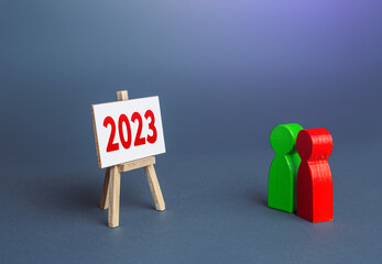 People look at 2023 year easel. Summing up, analytics and forecasting. Report presentation....