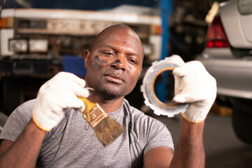 car mechanic engine mechanic cleaning engine parts in garage. Smiling auto mechanics in garage.