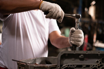 Auto mechanic working and repair on car engine in mechanics garage. Car service. male mechanic repairs car in garage. Car maintenance and auto service garage concept.