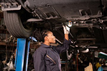 Obraz na płótnie Canvas African american Two mechanics - man examining car engine. Auto mechanic working in garage.Car Mechanic Detailed Vehicle Inspection. Auto Service Center Theme.