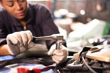 Fototapeta na wymiar African american technician female Mechanic working under the hood at the repair garage.