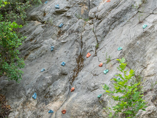 Sport equipment for rock climbing on natural rock. Training sports ground for mountaineering outdoors. Climbing hooks and holds on rock.