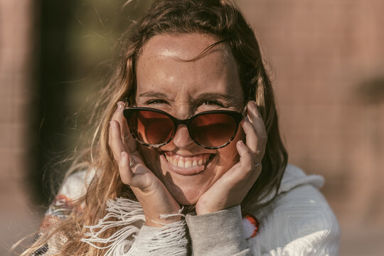 Retrato chica caucásica con gafas de sol sacando la lengua