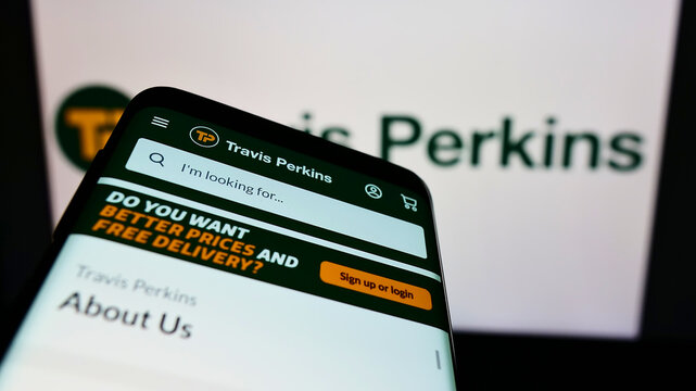 Stuttgart, Germany - 12-18-2021: Mobile phone with webpage of British retail company Travis Perkins plc on screen in front of business logo. Focus on top-left of phone display.
