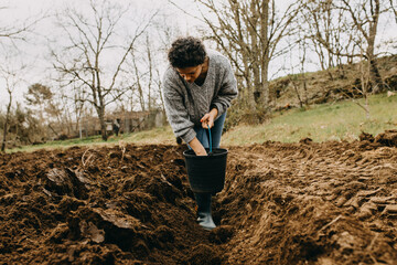 Woman sowing potatoes