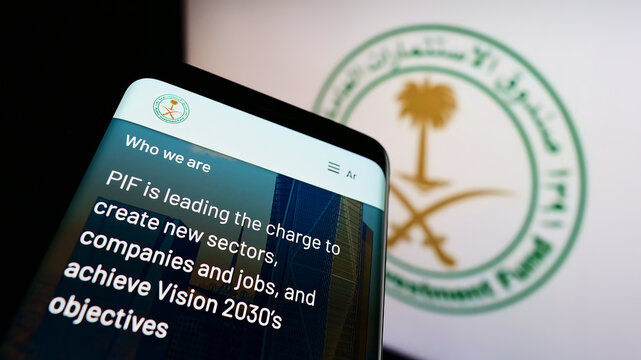 Stuttgart, Germany - 12-18-2021: Mobile phone with website of Saudi Arabian Public Investment Fund (PIF) on screen in front of business logo. Focus on top-left of phone display.