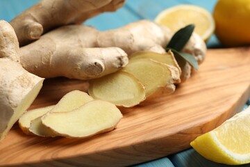 Cut ginger and lemon on wooden board, closeup
