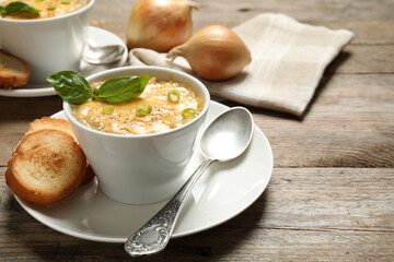 Tasty homemade french onion soup served on wooden table. Space for text