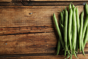 Fresh green beans on wooden table, flat lay. Space for text