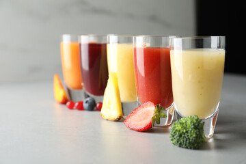 Delicious juices and fresh ingredients on grey table
