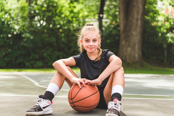 Naklejka premium girl with basketball on court on summer season