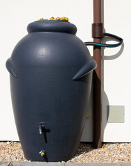 Rainwater barrel connected to the gutter, water saving concept