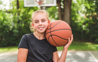 girl with basketball on court on summer season