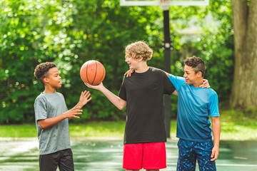 three teens friends in sportswear playing basketball game
