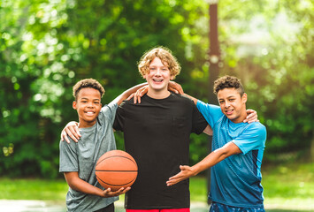 three teens friends in sportswear playing basketball game