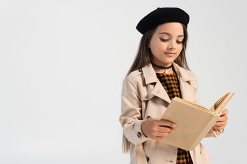 cute girl in stylish autumnal outfit and beret reading book isolated on grey.