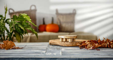 Autumn composition on a wooden table surrounded by green leaves and empty space