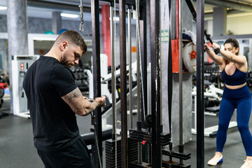 Fototapeta na wymiar Caucasian muscular man doing biceps exercises in the gym. Lifestyle, workout concept