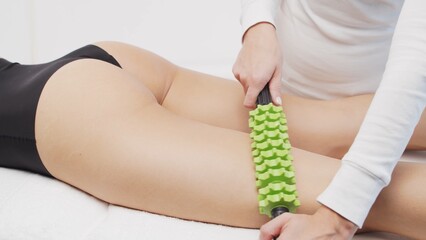 Therapist makes anti-cellulite massage using roller massager tool. Physiotherapy and recovery treatment concepts. - obrazy, fototapety, plakaty