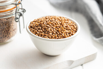 Uncooked buckwheat grain in bowl.