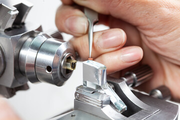 Closeup of a female scientist placing a sample on a transmission electron microscopy grid