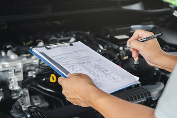 Car service concept, Close up hand car service staff check engine malfunctions and check list on...