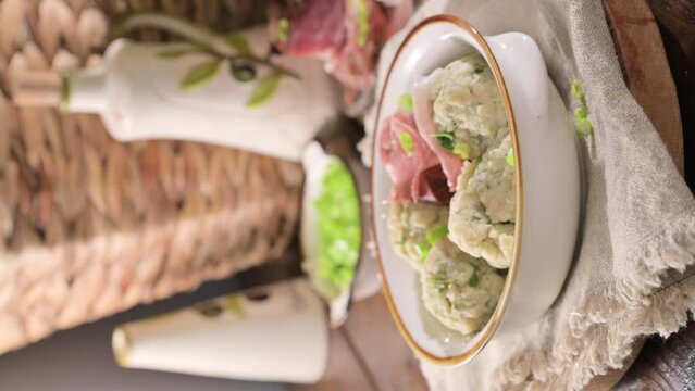 North italian traditional dish. Canederli or Knodel in broth with green onion, typical pasta for Trento, Alps, Alto Adige, Italian, Austrian cuisine. High quality 4k footage. Vertical video
