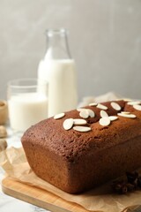 Delicious gingerbread cake with almond petals on table, space for text