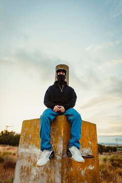 Boy with balaclava sitting while looking at the camera