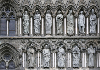 Fototapeta na wymiar Detail of sculptures featured on the facade of the Nidaros Cathedral, Trondheim, Norway.
