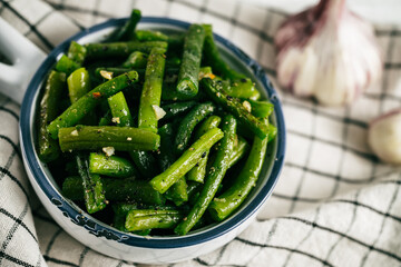 Baked green beans in a dish on a linen towel - obrazy, fototapety, plakaty