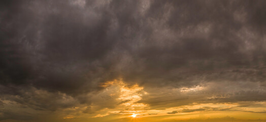 Fototapeta na wymiar Thunder clouds with yellow sunset background
