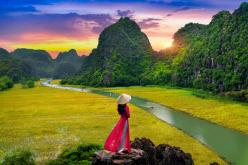 Asian woman wearing Vietnam culture traditional at Tam coc, Vietnam.
