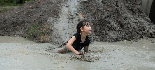 Little girls have fun playing in the mud in the community fields