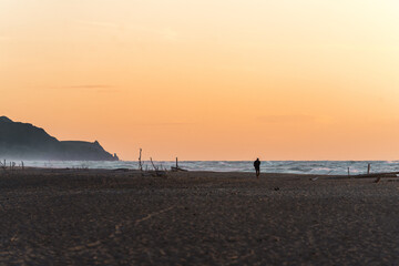 Silhouette einer einsamen Figur am Strand bei Sonnenuntergang 