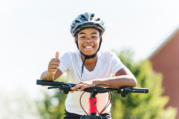 boy riding bike wearing a helmet outside