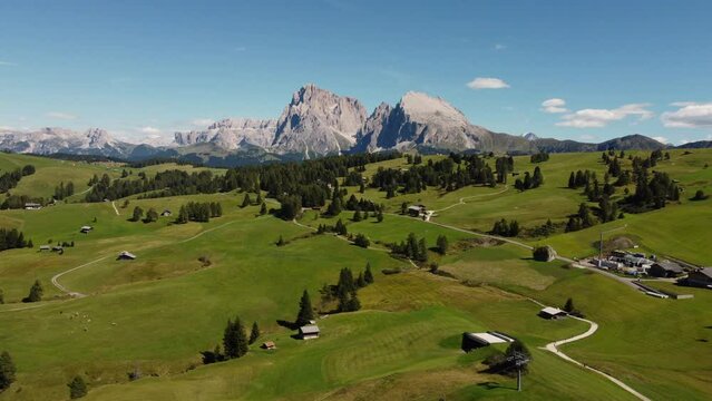 Seiser Alm Alpe di Siusi and Chalet in Dolomites near Compatsch, Compaccio Italy. Sassolungo and Sassopiatto mountai range, Langkofel and Plattkofel aerial view. South Tyrol Trentino Alto Adige, Italy