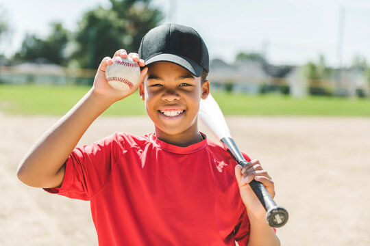 portrait of child with glove and looking at camera playing baseball