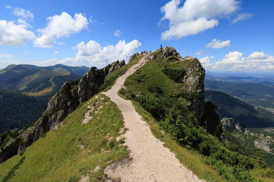 Velky Rozsutec, Mala Fatra, Slovakia. Unidentifiable tourists, hikers and trippers on the rocky top of the mountain and hill. Sunny summer with blue sky. 