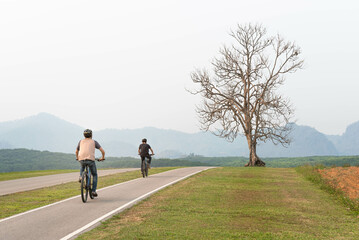 People are doing exercises on bicycles on the streets in the park.