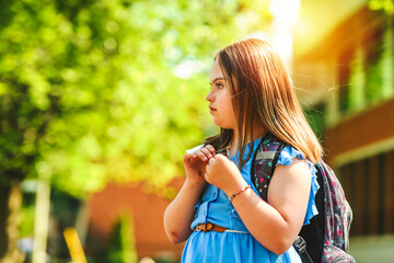 portrait of trisomy 21 child girl outside on a school playground