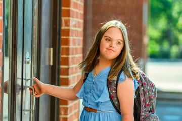 portrait of trisomy 21 child girl outside on a school playground