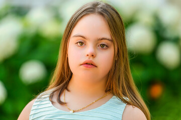 portrait of trisomy 21 child girl outside on a park